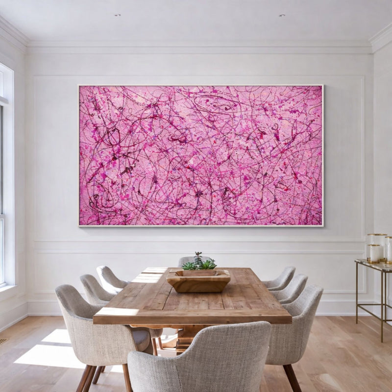 Dining room with a large pink abstract painting on the wall above a wooden table.