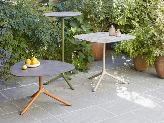 SCAB Tripè round outdoor bistro table with an olive green powder-coated aluminium base, paired with a lounge armchair in a contemporary garden patio setting, ideal for cafés, hotels and residential terraces.