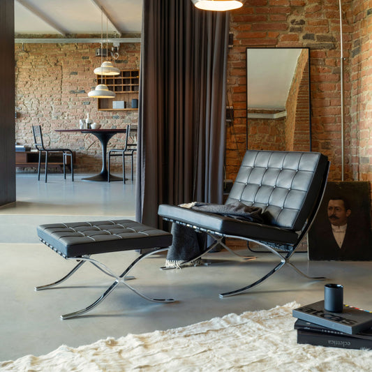 Barcelona Chair with matching ottoman in black tufted leather and polished chrome frame, iconic modern lounge seating for luxury living rooms, offices, reception areas and contemporary interiors.