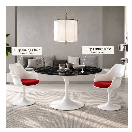Black marble round Eero Saarinen Tulip dining table with a white pedestal base paired with two white Tulip armchairs featuring red upholstered seat cushions in a contemporary living and dining space.