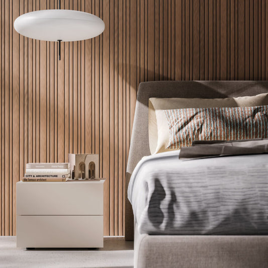 Modern bedroom with a bed, nightstand, and wall lamp.