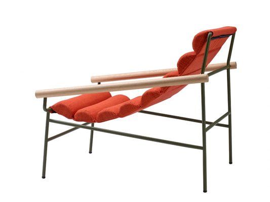 Rear angled view of the Dress Code Fashion lounge chair with red cylindrical cushions, natural wood armrests, and a slim olive green metal frame.