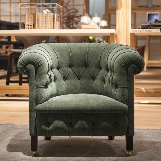 Green velvet Chesterfield tub armchair with deep button tufting, rolled arms, brass castors and a cushioned seat in a classic British design.