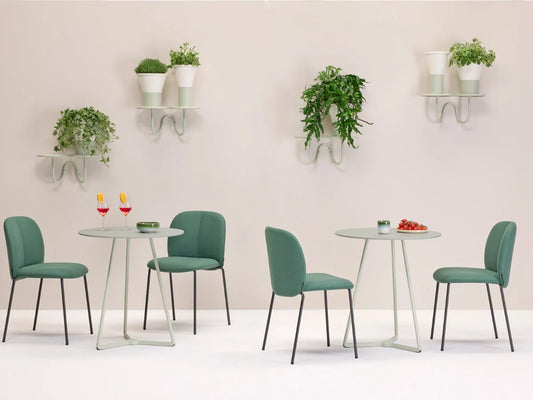 Mentha Pop 2720 upholstered dining chairs in sage green arranged around modern dining tables in a contemporary interior.