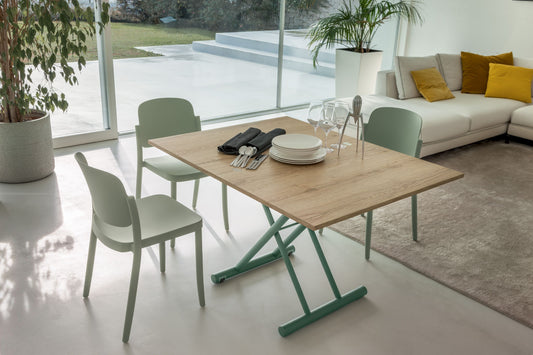 Oak dining table with green metal base in bright modern living space with chairs