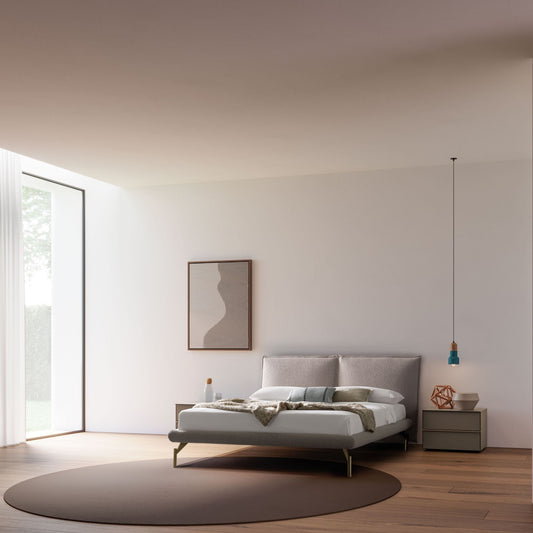 Modern bedroom with a bed, side table, and abstract art on a white wall.