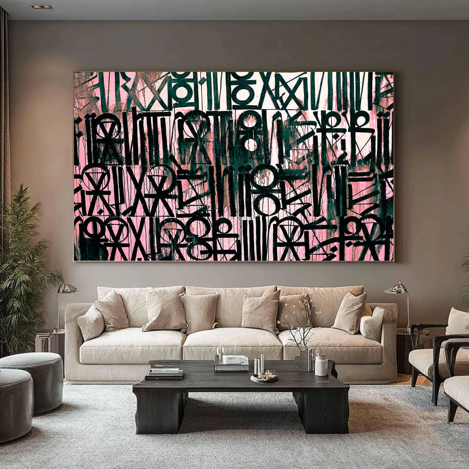 Large black calligraphy wall art on pink background styled in a modern living room interior.