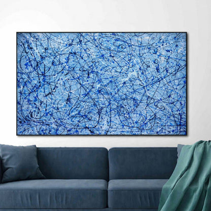 Abstract blue painting on a wall above a blue sofa