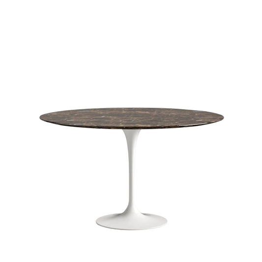 Round dining table with dark brown marble top and white base on a white background