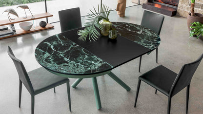 Helios extendable dining table by Altacom shown fully extended with green marble-effect top and black chairs