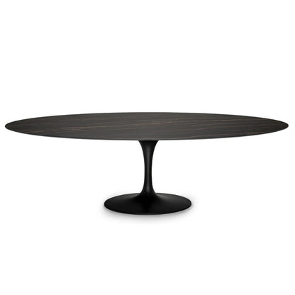 An oval-shaped tulip dining table with a matte black aluminum base and a glossy marble top.