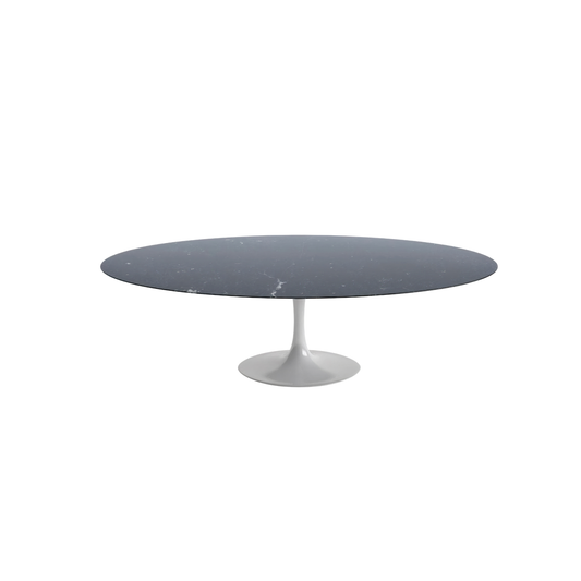 Round tulip dining table with a dark gray marble top and white base on a white background