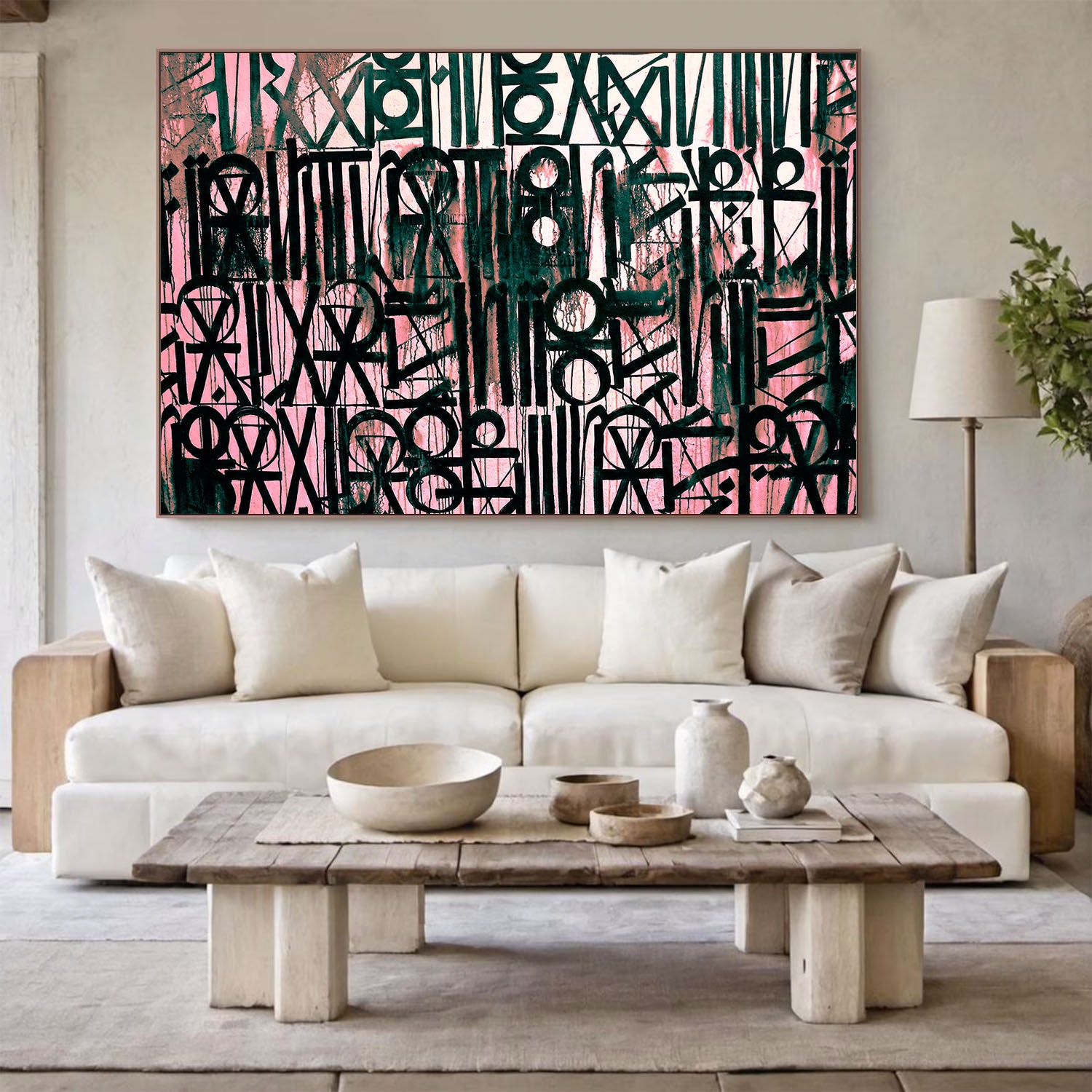Modern living room with a white sofa, wooden coffee table, and abstract artwork on the wall.