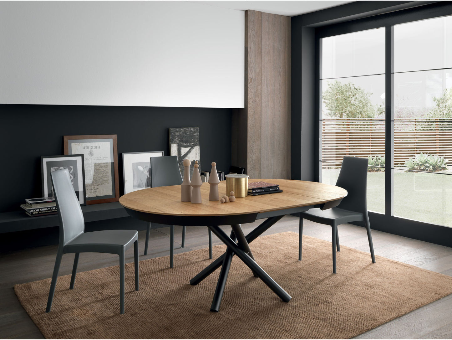 Dining room with a round wooden table and chairs near a large window.