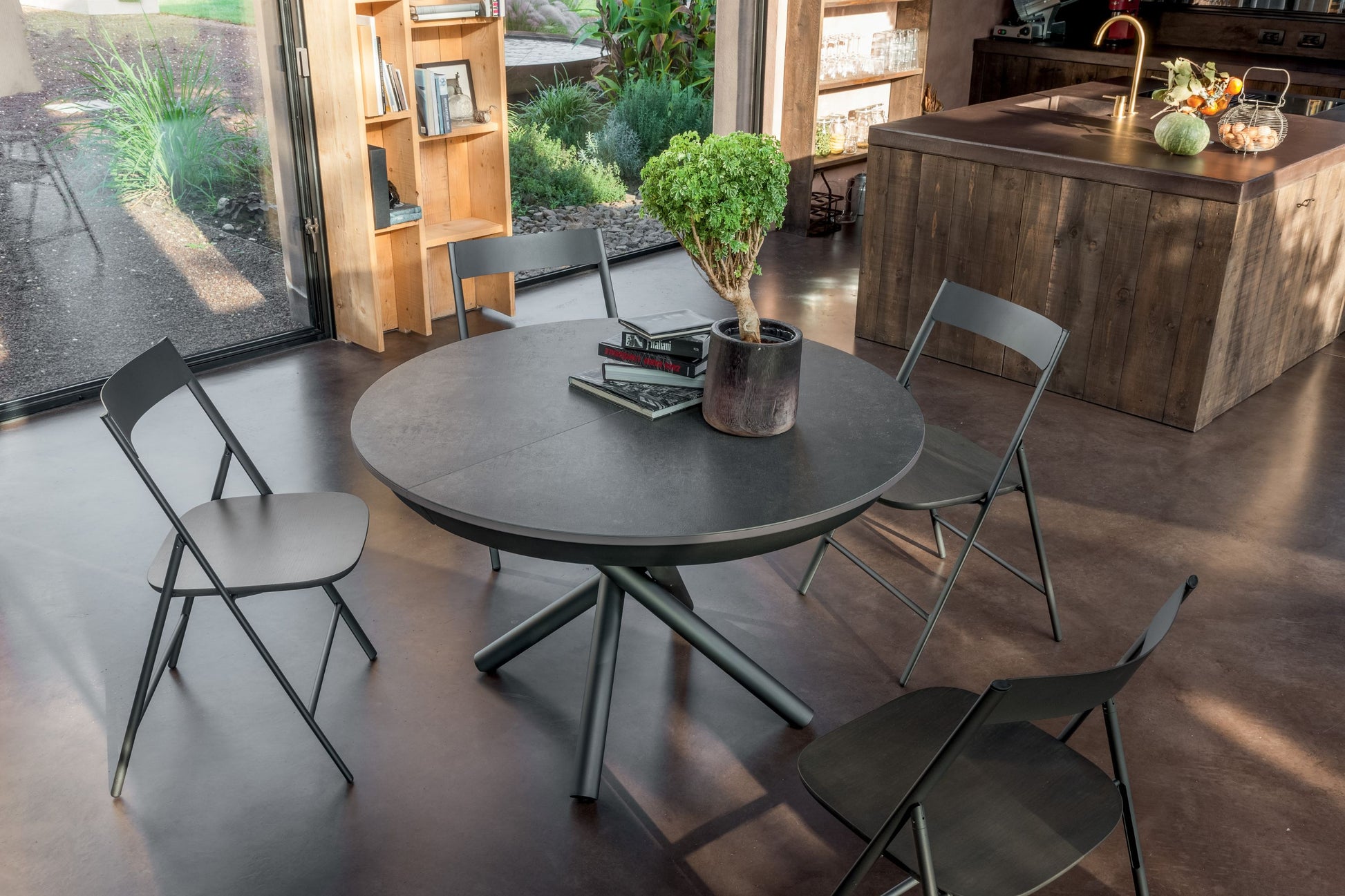 Round black table with four chairs in a modern kitchen setting