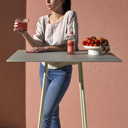 Close-up of the S•CAB Atomo Bistro Table Base with a square bar-height tabletop in a contemporary outdoor hospitality setting.