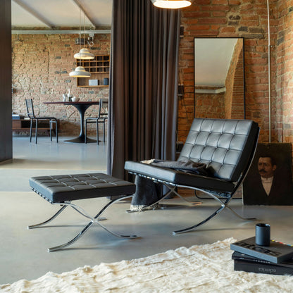 Barcelona Chair with matching ottoman in black tufted leather and polished chrome frame, iconic modern lounge seating for luxury living rooms, offices, reception areas and contemporary interiors.