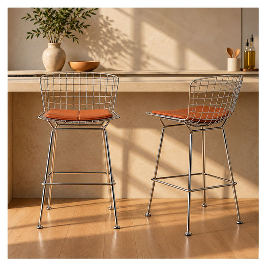 Pair of Bertoia-inspired chrome wire counter stools with tan cushions beside a kitchen island