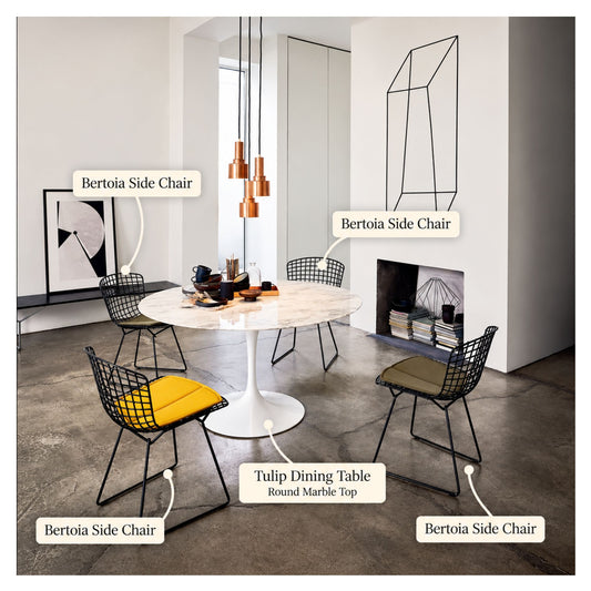 Harry Bertoia inspired wire dining chairs with black welded steel grid frames and colourful upholstered seat pads arranged around a round white marble Tulip pedestal dining table in a contemporary dining room, combining iconic mid-century modern design with sculptural elegance
