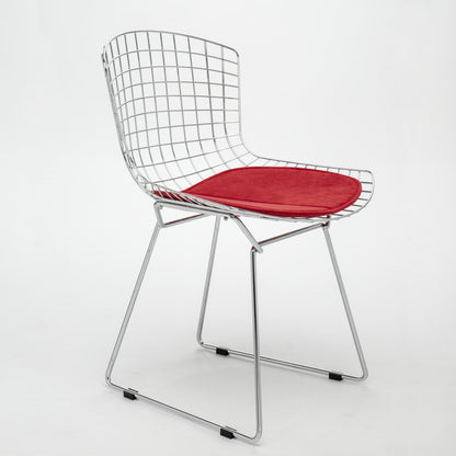 Modern Bertoia wire side chair with a bronze metal frame and red upholstered seat cushion on a white background.