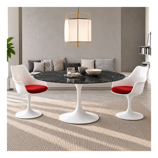 Black marble round Eero Saarinen Tulip dining table with a white pedestal base paired with two white Tulip armchairs featuring red upholstered seat cushions in a contemporary living and dining space.
