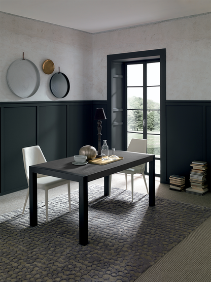 Modern black rectangular dining table in minimalist dining room with white chairs