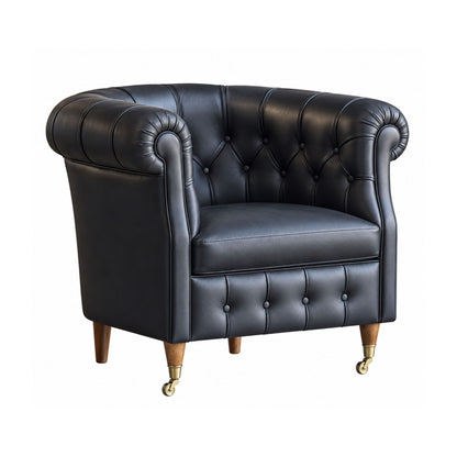 Black upholstered club armchair with a button-tufted back, wood legs and brass front castors