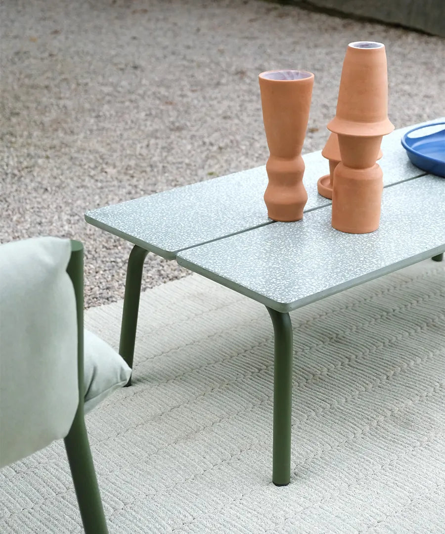 Close-up of the S•CAB Brezza outdoor coffee table with a textured glass tabletop in a contemporary garden lounge setting.
