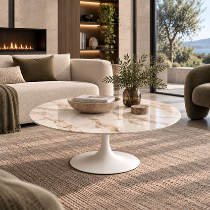 Calacatta Gold marble-effect oval Tulip coffee table with a white pedestal base styled in a contemporary luxury living room with elegant modern décor.