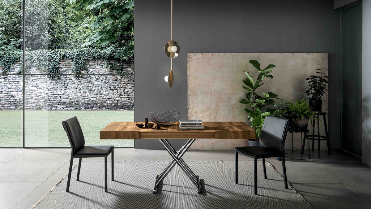 Calypso transforming dining table by Altacom with thick old oak wood top and polished chrome metal base in a contemporary dining room