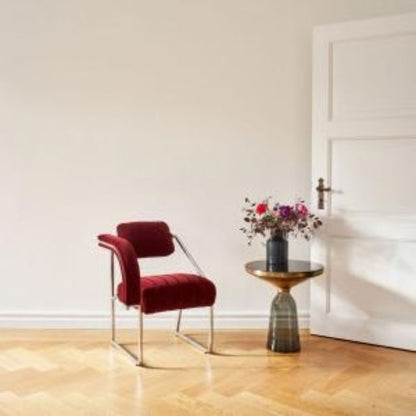 Modern cantilever armchair upholstered in rich red velvet with a polished chrome tubular steel frame, featuring a curved padded armrest, ribbed seat and minimalist Bauhaus-inspired design for luxury dining rooms, lounges, boutique hotels and contemporary interiors.