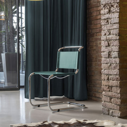 Modern cantilever dining chair with aqua leather seat and backrest on a polished chrome tubular frame in a contemporary interior.