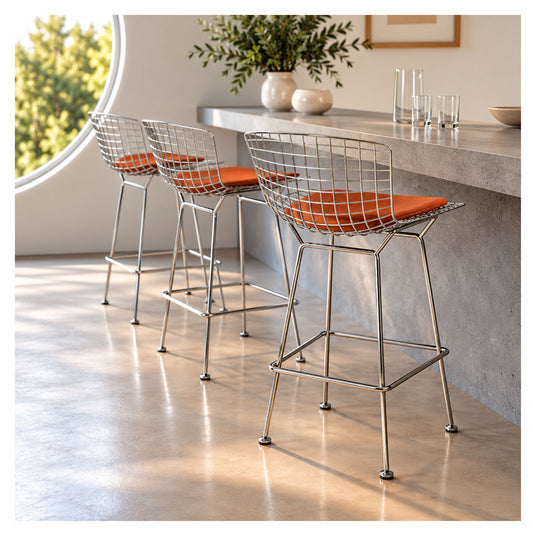 Chrome wire counter stools with upholstered cushions arranged at a modern kitchen island