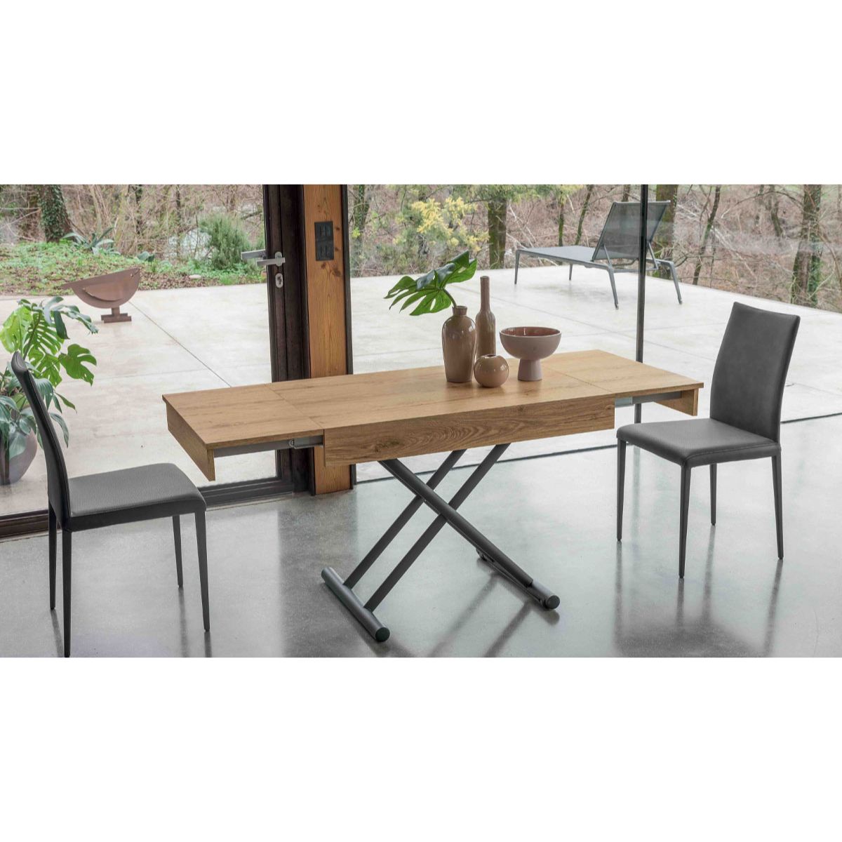 Compact convertible table by Altacom extended into dining table with chairs showing space saving design and X frame base