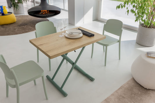 Compact oak dining table with green base and chairs in modern open living area