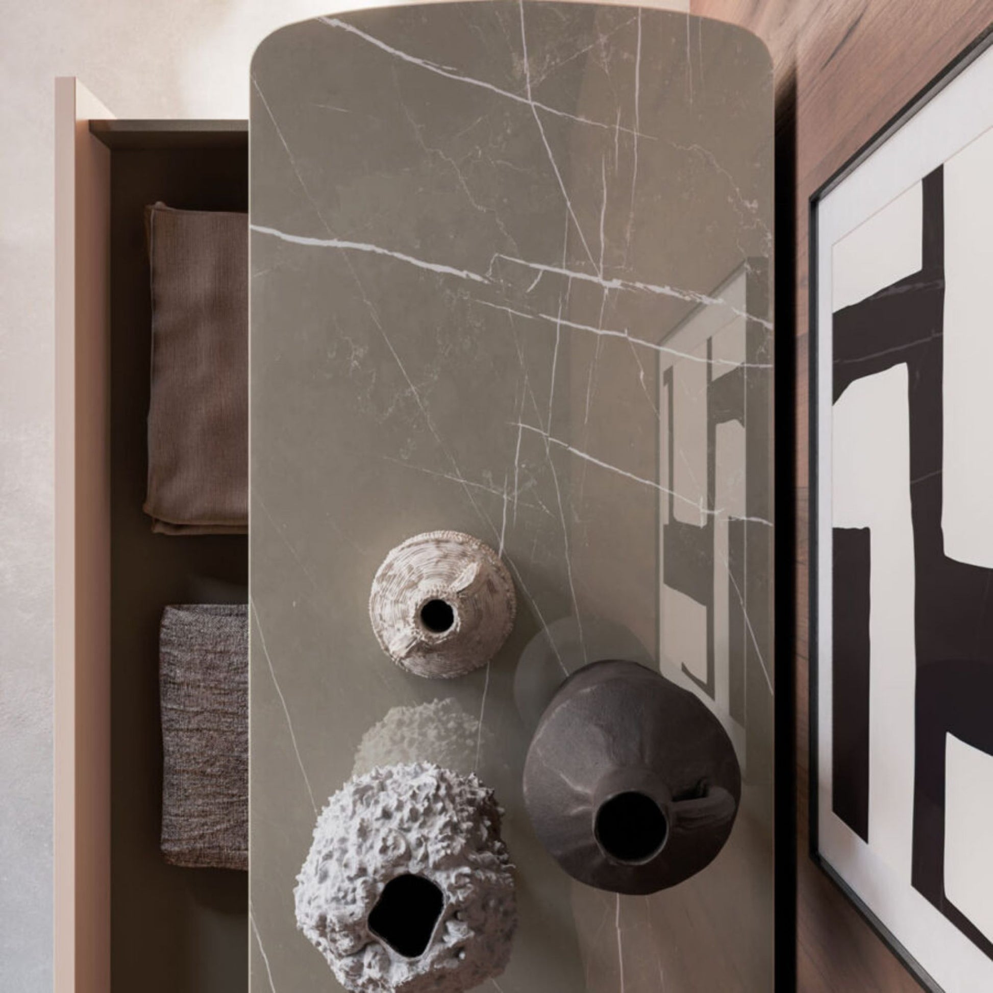 Decorative vases on a marble-patterned surface with a modern interior setting.
