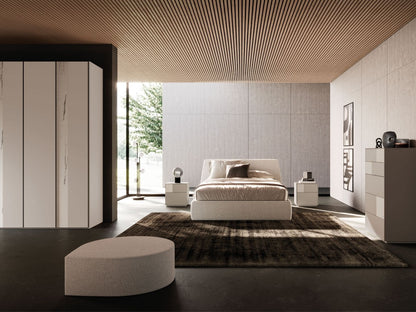 Modern bedroom with a bed, rug, and side tables in a stylish interior.