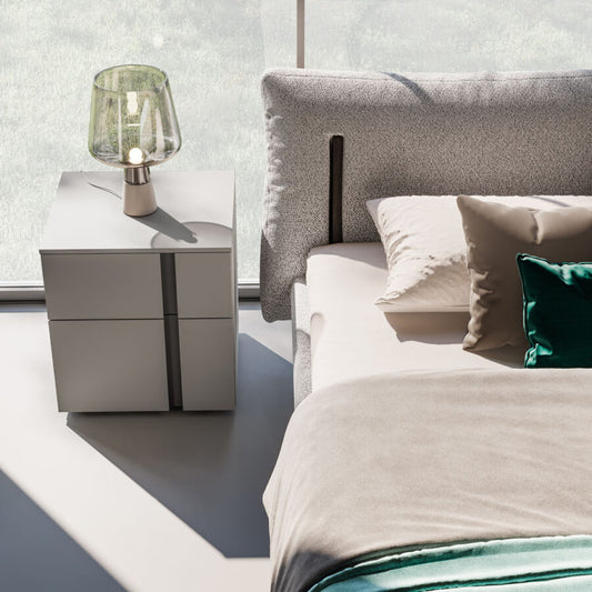 Modern bedroom with a bed and nightstand featuring a lamp.