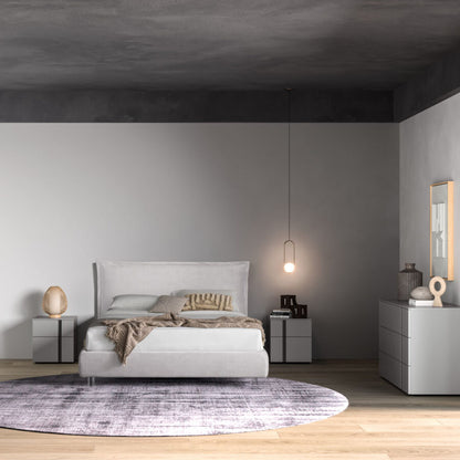 Modern bedroom with a bed, nightstands, and a rug.