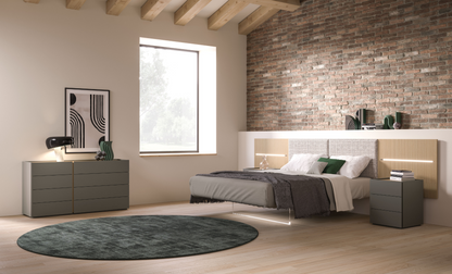 Modern bedroom with wooden ceiling, brick wall, and furniture.
