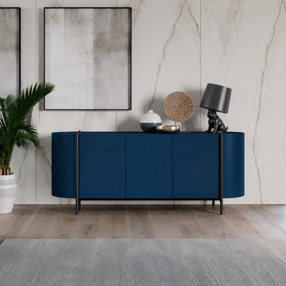 Dall'Agnese Supernova modern navy blue sideboard or credenza with curved front panels and slim black legs, styled in a contemporary room with a marble wall, framed art, a potted plant, and decorative objects on top.
