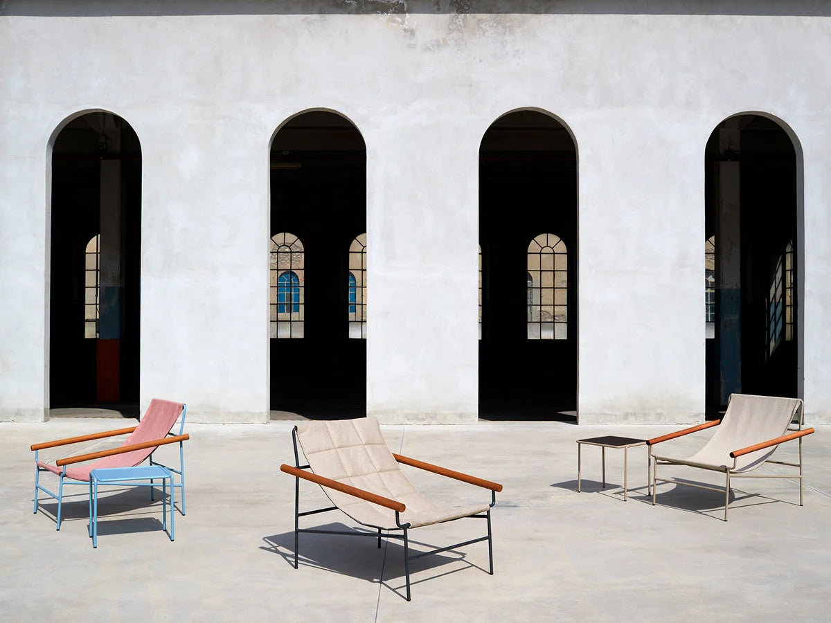Dress Code Glam 2582 lounge chair collection in multiple colours displayed in a modern architectural outdoor courtyard.
