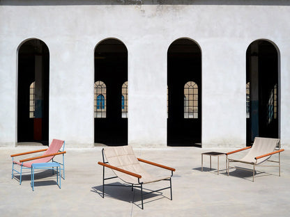 Dress Code Glam 2582 lounge chair collection in multiple colours displayed in a modern architectural outdoor courtyard.