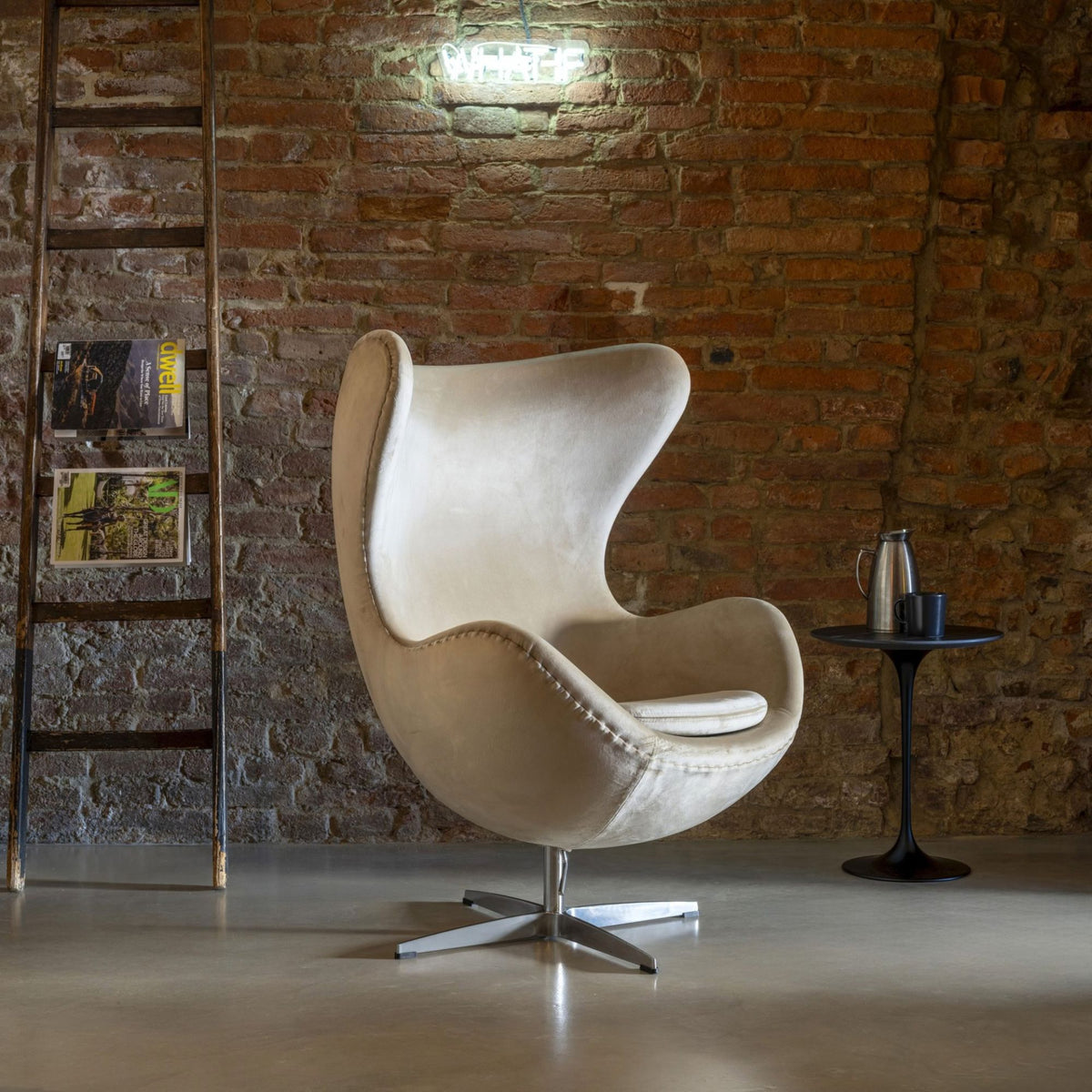 Cream velvet Egg Chair with a polished aluminium swivel base, featuring a sculptural high-back wing design for modern living rooms, hotel lounges, executive offices and luxury contemporary interiors.