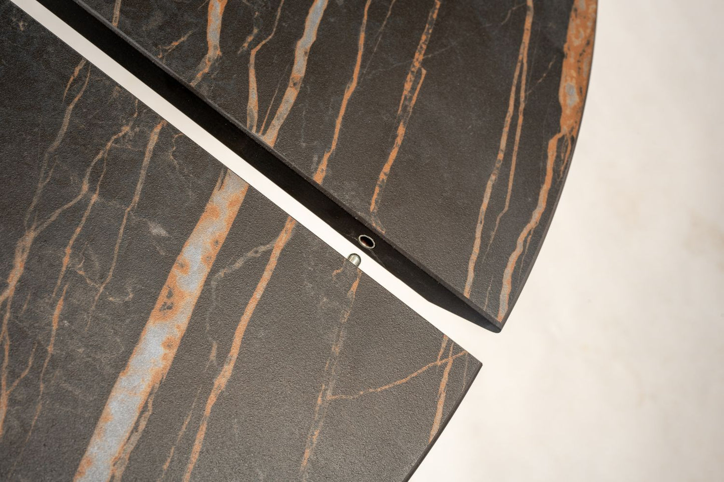 Close-up of extendable marble tulip dining table with leaf extension open showing marble surface and joining mechanism