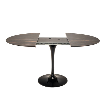 Extendable oval marble tulip dining table with leaf extension open, dark marble top and black pedestal base on white background