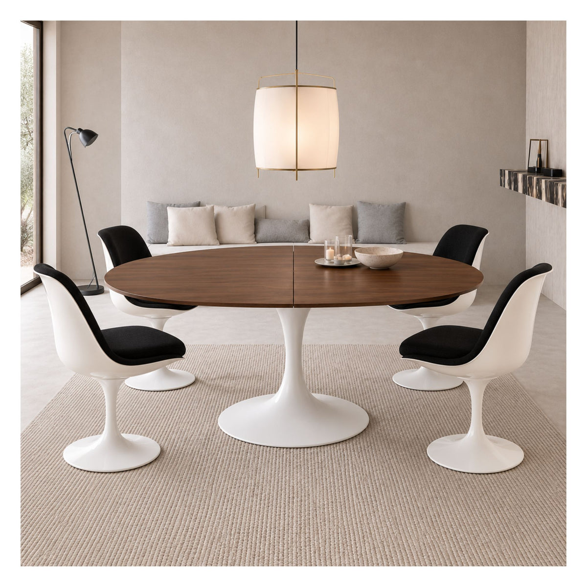Extendable Tulip dining table with a dark wood top and white pedestal base, surrounded by four white chairs with black seats.