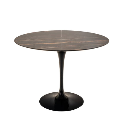 Extendable round marble tulip dining table with dark marble top and black pedestal base on white background