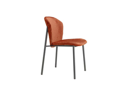 Side view of the Finn 2893 upholstered dining chair with rust fabric upholstery and slim dark metal legs.