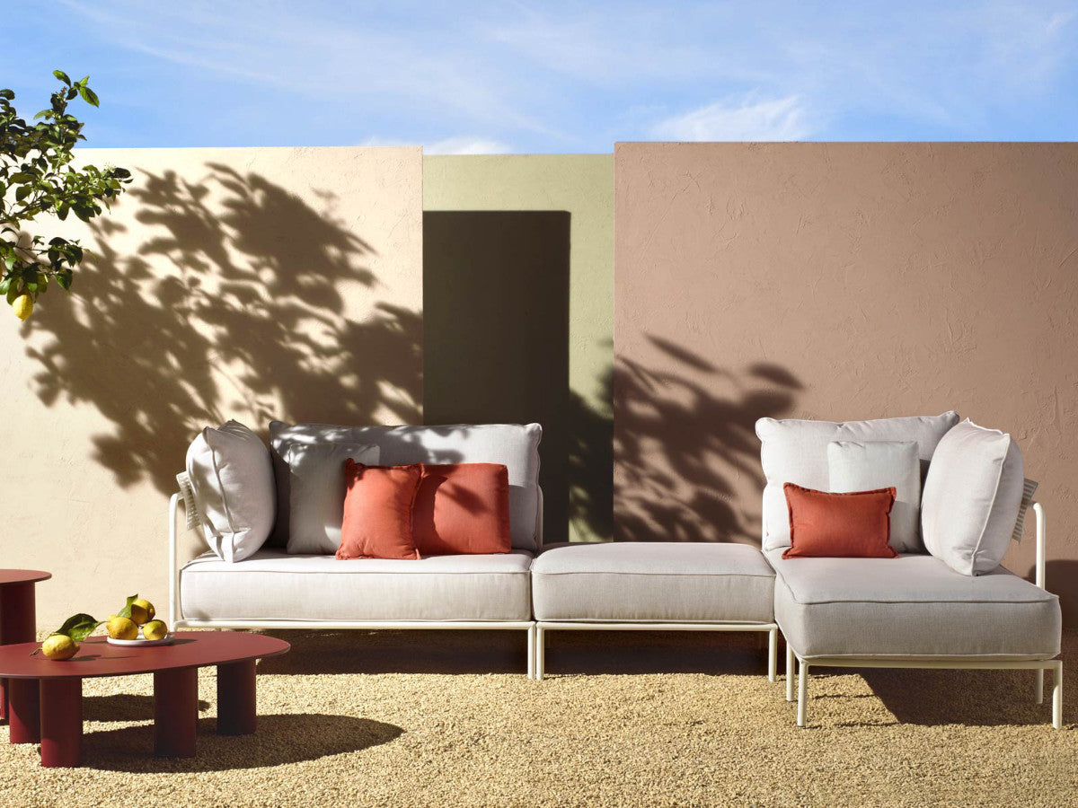 Flap 2902 modular outdoor sofa with cream cushions and terracotta accent pillows arranged on a contemporary patio.